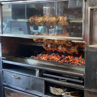 The rotisserie pit chicken Cooke over an open fire pit