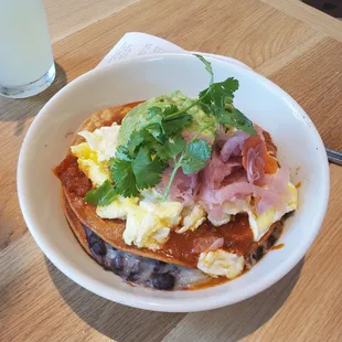 Bowl: Rancheros. Two Fried Eggs, Crispy Corn Tortillas, Black Beans, Jack Cheese, Guacamole, Pickled Onions (Vegetarian)