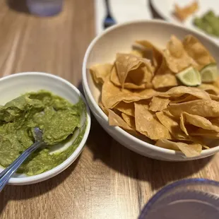 a bowl of chips and a bowl of guacamole