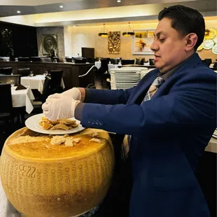 Franklin carving 14-month old Aged Parmesan Cheese from the Wheel