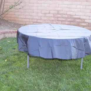 Here's an example of our Round table with an 84" plastic tablecloth. (Tablecloths not available for rent)