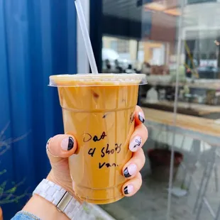 a hand holding a cup of iced coffee