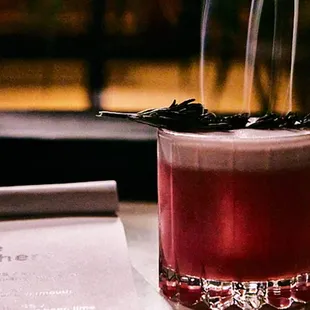 a glass of wine and a menu on a table