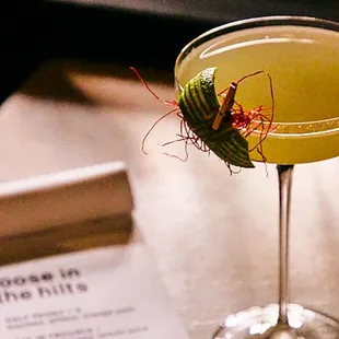 a yellow cocktail in a coupe glass