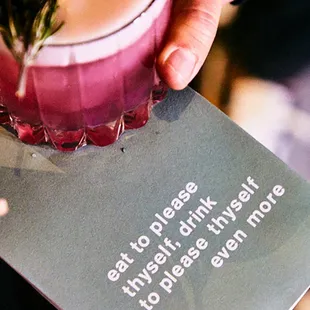 a person holding a drink in a glass