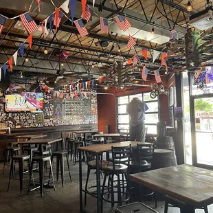 a restaurant with tables, chairs, and flags hanging from the ceiling