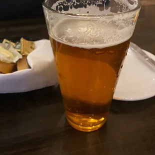 a glass of beer and a plate of food