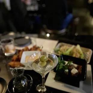 a martini with olives on a table