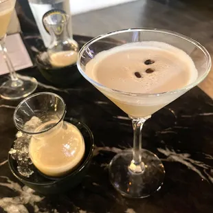 a martini and two glasses on a table