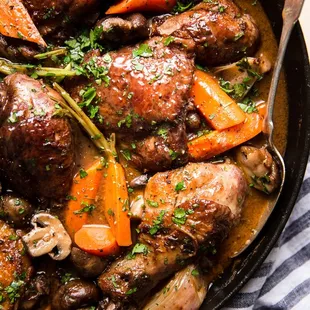 a skillet filled with meat and vegetables