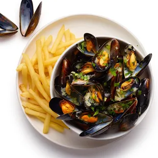 a bowl of mussels and fries
