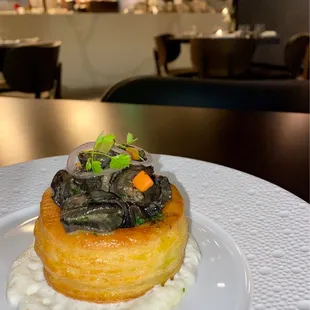 Escargot on a puff pastry placed on horseradish cream.