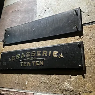 a sign on a stone wall