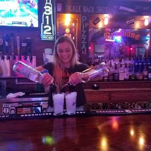 a woman pouring a drink at a bar