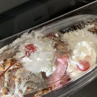 Messy Sundae with ice cream everywhere, even on the top of the lid.