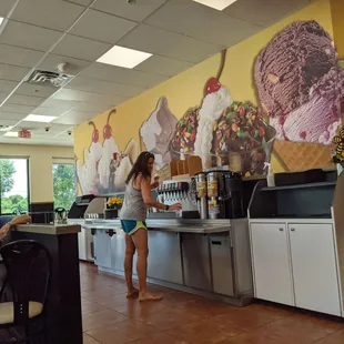 a woman standing in front of an ice cream shop