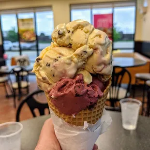 a hand holding a cone of ice cream