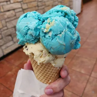 a hand holding a cone of ice cream