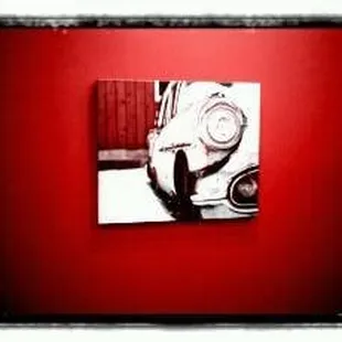 a red wall with a black and white picture of a car