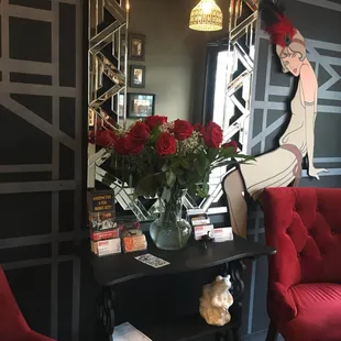 a woman sitting on a red chair in front of a mirror