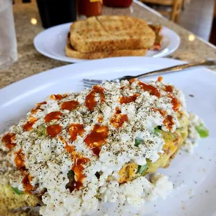 Vegetable omelet with sausage cut up inside, then smothered in cottage cheese and Cholula sauce!  And some Rye toast!