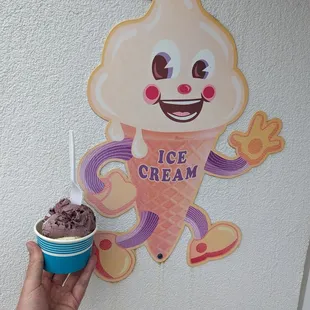 a hand holding a cup of ice cream