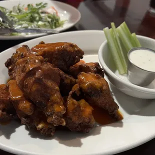 a plate of wings and a bowl of ranch dressing