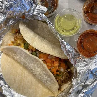 two tacoss wrapped in tin foil