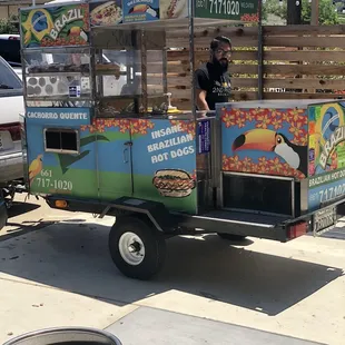 a man selling hot dogs from a cart