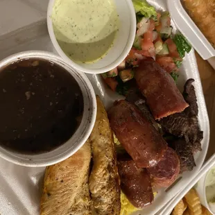 Chicken, sausage, steak, black beans, yellow rice, and salad.