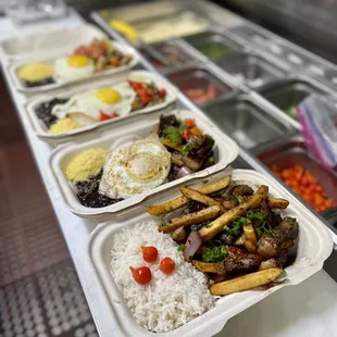 a row of trays of food