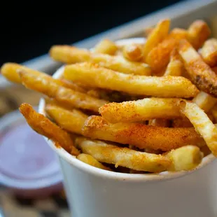 a cup of french fries on a tray