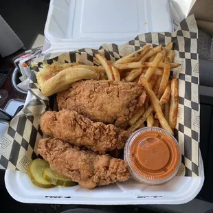 Three chicken tenders with fries, garlic bread , buffalo sauce and Brd sauce with pickles on the side