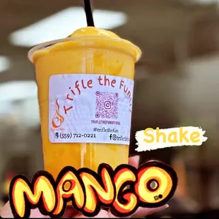 a hand holding a cup of mango juice