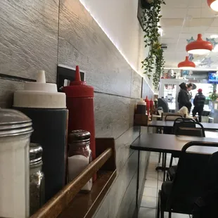 Smart use of shelving at each table to keep condiments up off the table top clean and available