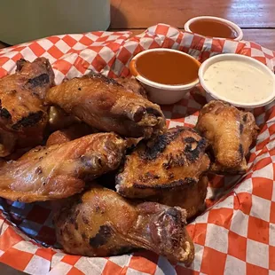 a basket of chicken wings with dipping sauce