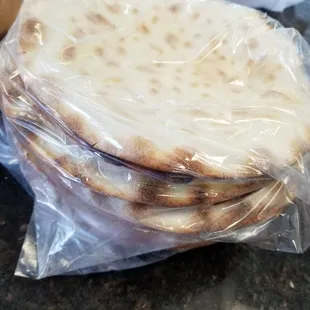 a stack of flatbreads wrapped in plastic