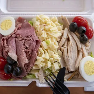 a sandwich and salad in a styrofoam container