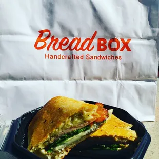 Duck Prosciutto Bread Box Melt with Mozzarella, Tomatoes, and Spinach.
