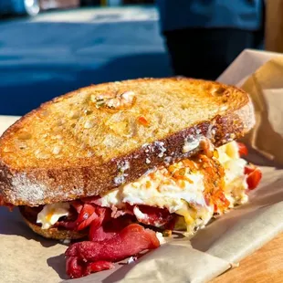 a grilled sandwich on a wooden cutting board