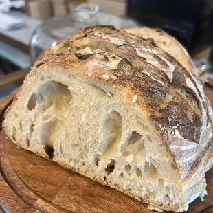 Warm fresh sourdough bread with homemade honey butter and raspberry jam