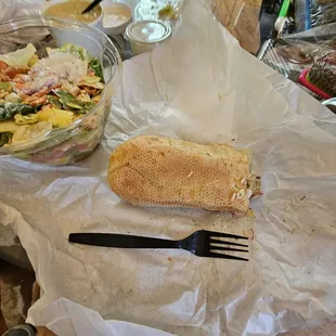 a sandwich and salad on a table