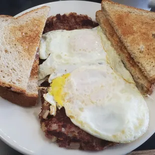 Two eggs on corned beef hash with sunflower toast.