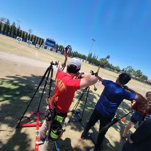 Two vision-impaired archers using tactile adaptive equipment to shoot archery. Distance is 30 meters (33 yards).