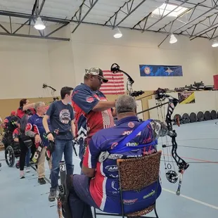 Physically Challenged veterans shooting archery with able bodied veterans