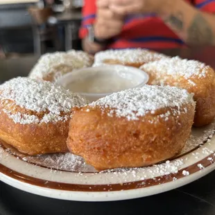 a plate of doughnuts with powdered sugar