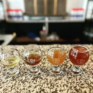 four glasses of beer on a counter