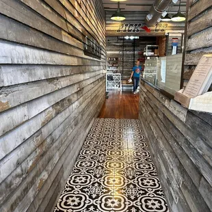 a woman walking down a long hallway