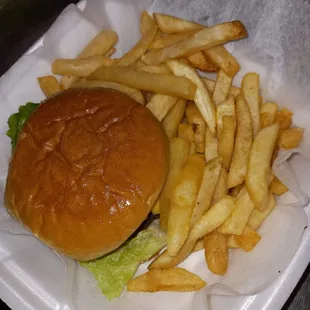 a hamburger and french fries in a styrofoam container