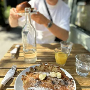 a plate of french toast with bananas and powdered sugar